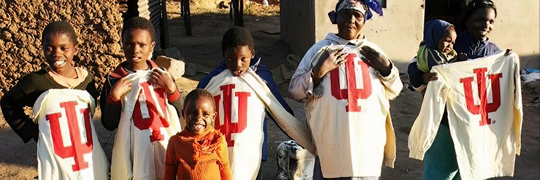 Members of the community at location of a study abroad program with IU shirts