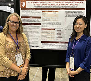 Two women standing in front of a poster.