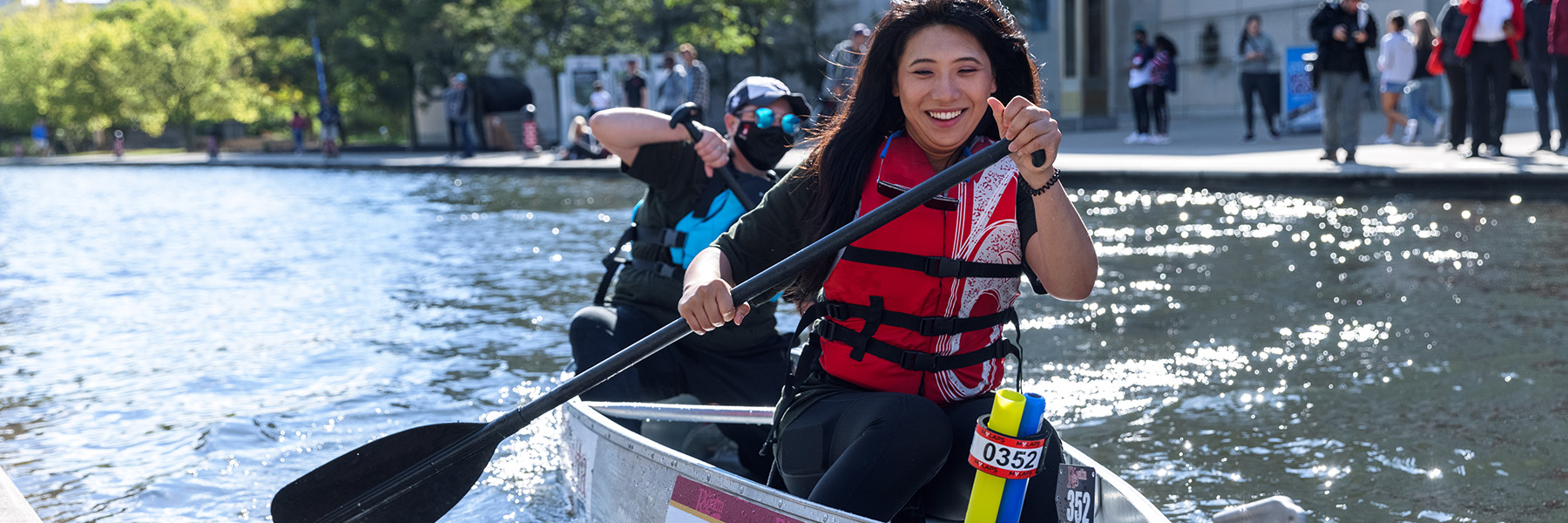 Students padding canoe in Canal