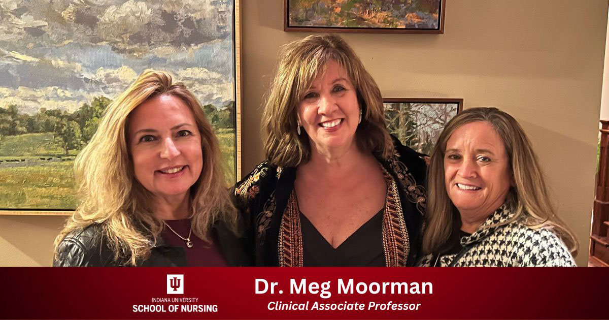 Dr. Meg Moorman poses with two other women with art in the background
