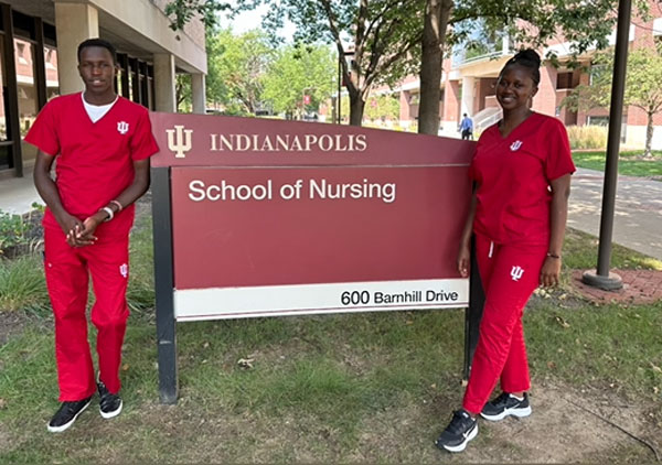 Moi University students Victor Kiplagat and Olivia Watta pose for a photo by the IU School of Nursing in Indianapolis sign.