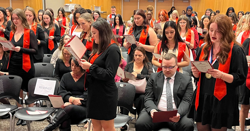 IU School of Nursing in Indianapolis December 2024 BSN graduates recite the IU School of Nursing pledge during a pinning ceremony.