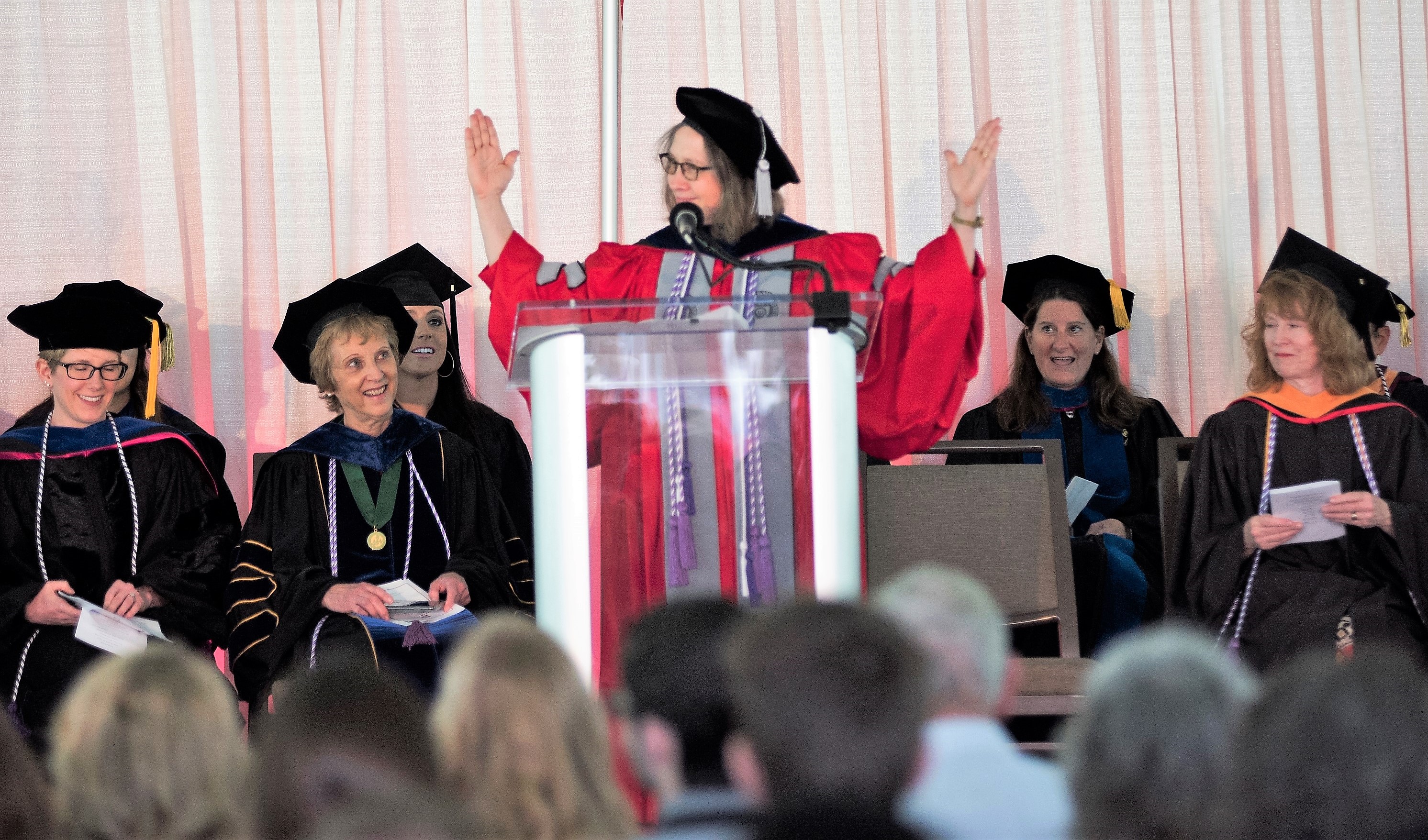 Speaker at podium in cap and gown