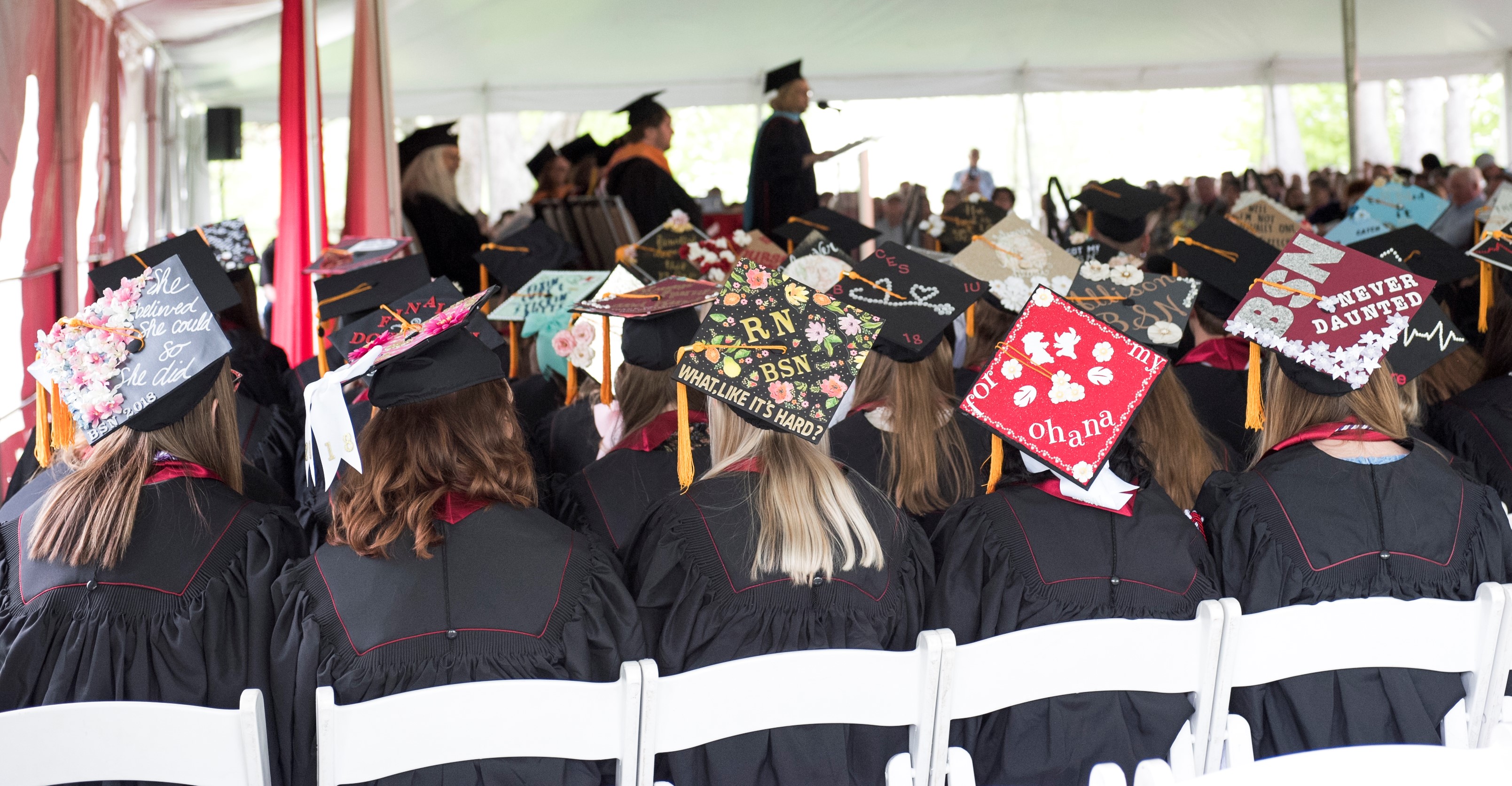 Graduates seated with decorated mortar boards displayed