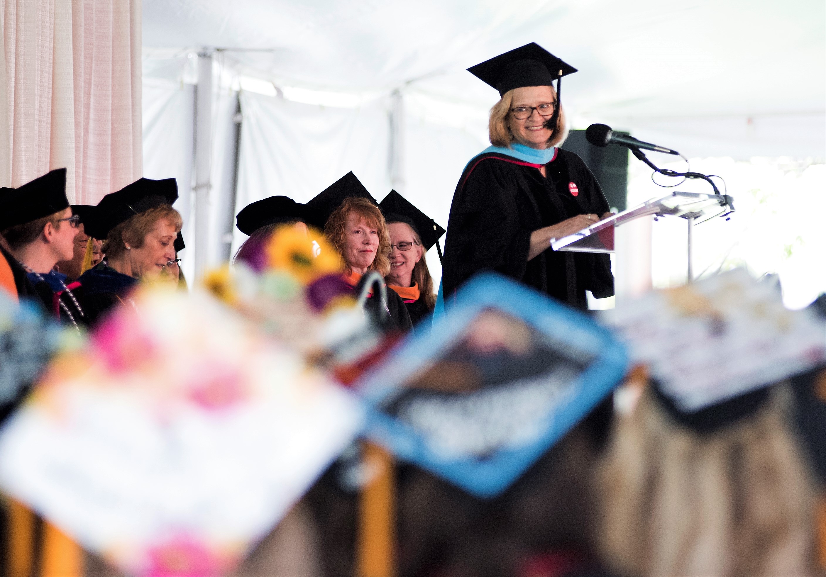 Faculty member speaking at podium during commencement