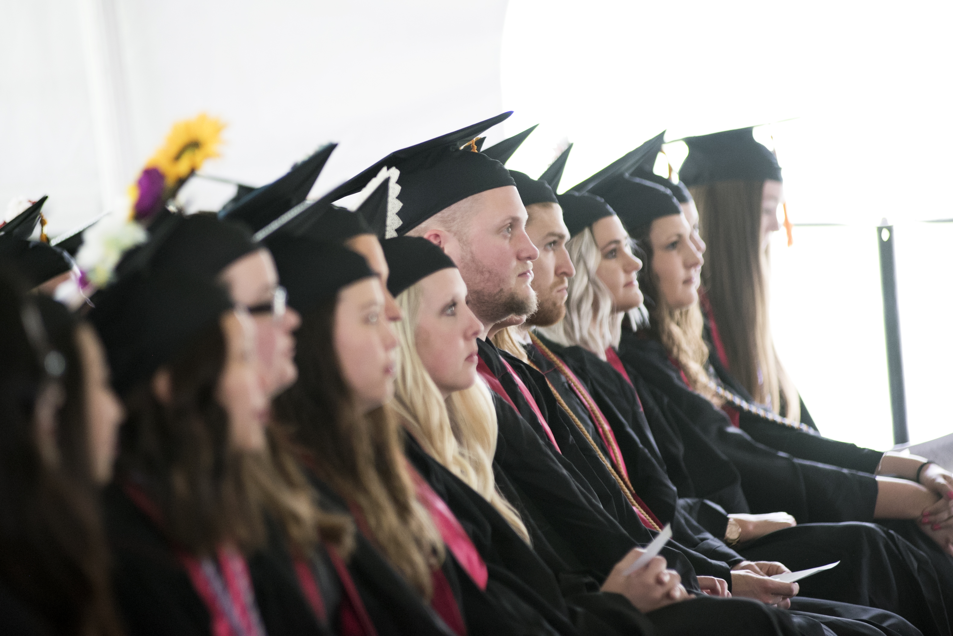 Row of students in caps and gowns at commencement