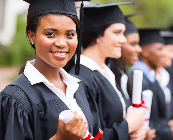 Graduate in cap and gown looking at camera