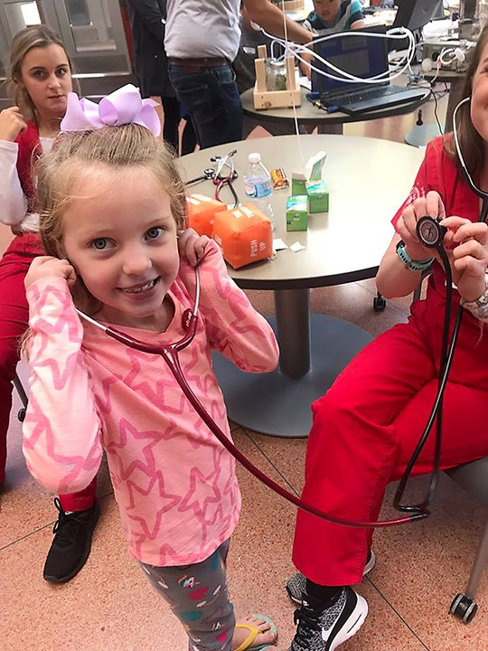 Child listens through stethoscope at Science Fest