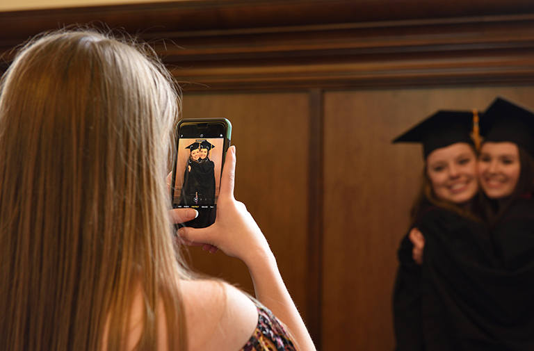 Photo of a person taking a photo of graduates