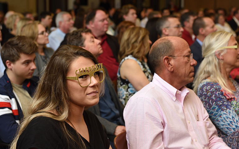 Group of people with a graduate wearing silly glasses