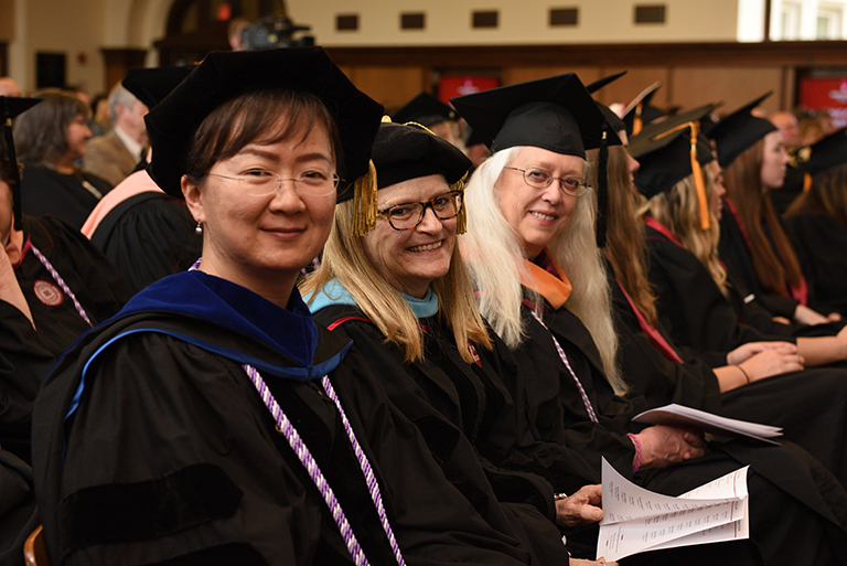 three faculty in commencement regalia