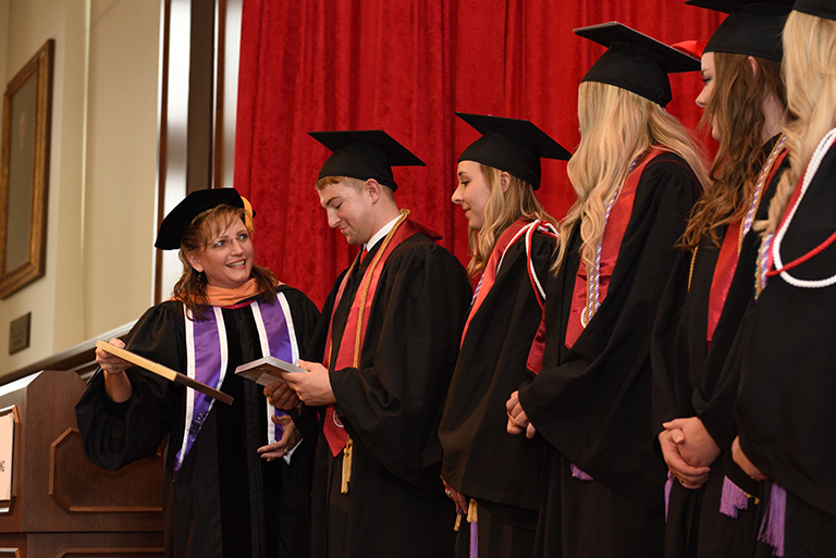 row of graduates with faculty