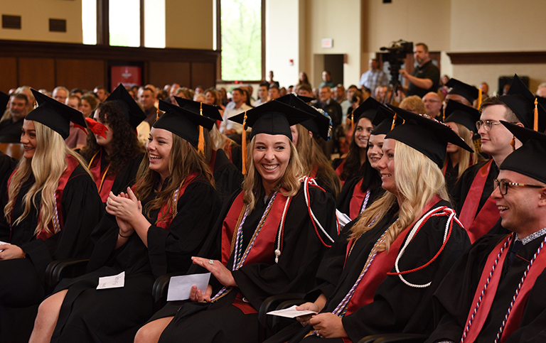 seated graduates applauding