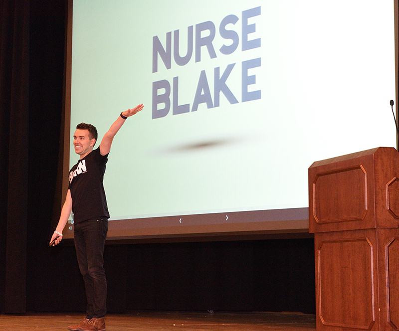 Man in front of video screen with message "Nurse Blake."