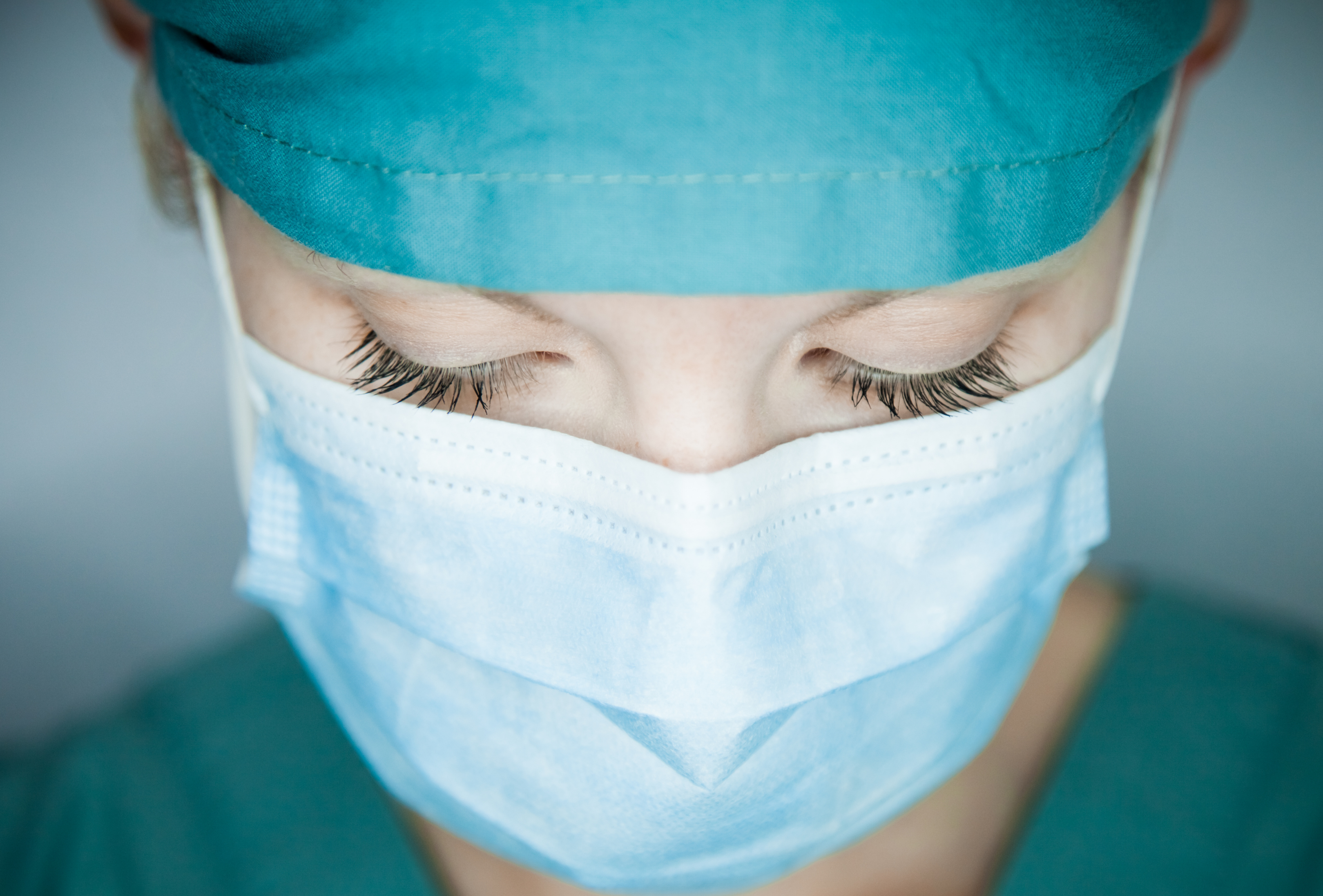 Face of a masked nurse looking down